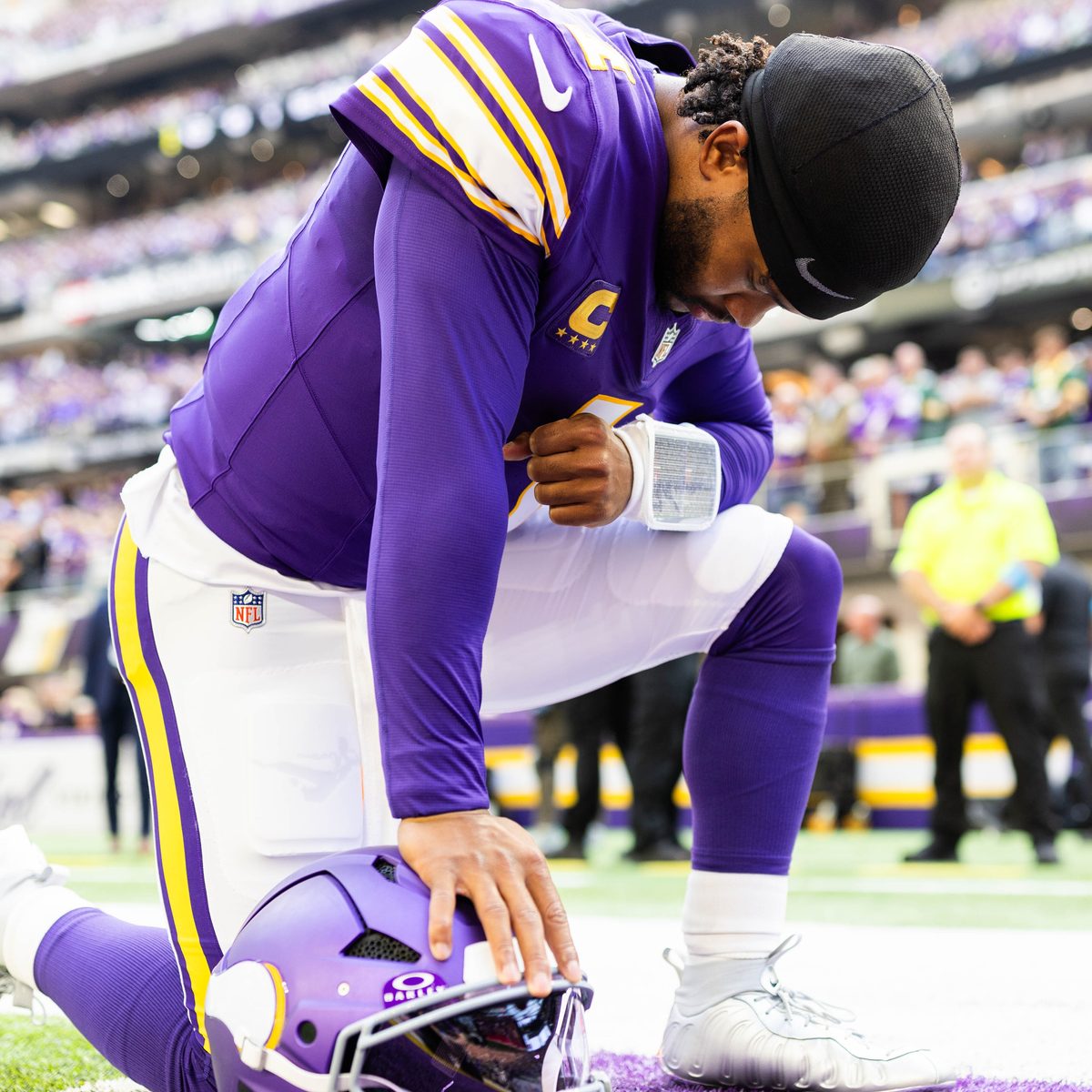 Kyler Murray kneeling on the field before a Minnesota Vikings game