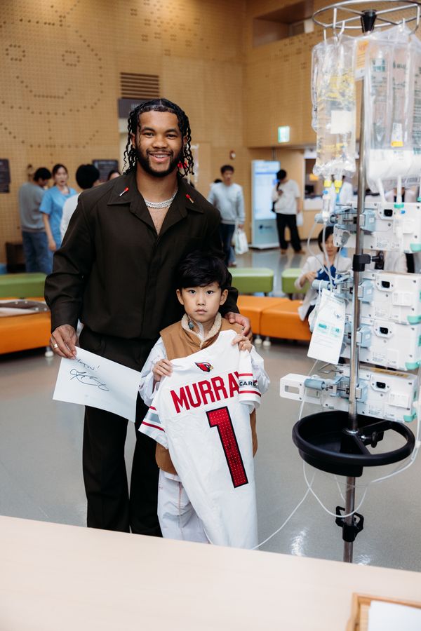 Kyler with a young patient holding a signed jersey