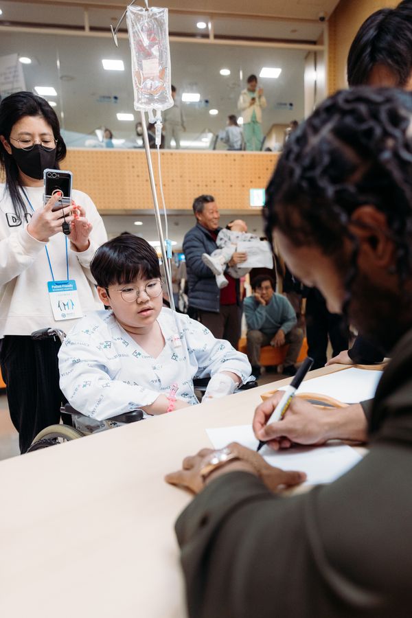 Kyler signing an autograph for a young patient